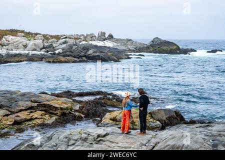 Ein junges Paar, das sich an der felsigen Küste Zentralchilens, Südamerika, unterhalten hat. Stockfoto