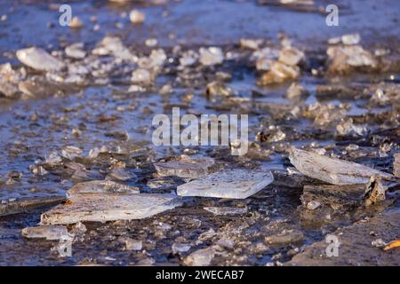 Eisstücke auf einem Feldweg mit Splittern und gebrochenem Eis im Klimawandel auf einem Feldweg auf einem landwirtschaftlichen Feld Stockfoto
