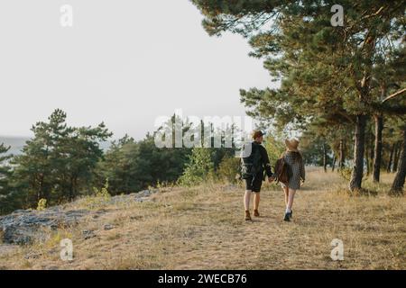 Ein verliebtes Paar hält Hände beim Wandern in den Bergen. Rückansicht. Stockfoto