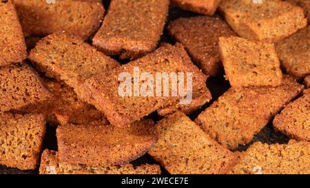 Nahaufnahme von frisch gebackenen Brotscheiben mit Paprika auf dunklem Hintergrund. Die warmen, goldenen Töne schaffen eine gemütliche und einladende Szene, die perfekt für Stockfoto