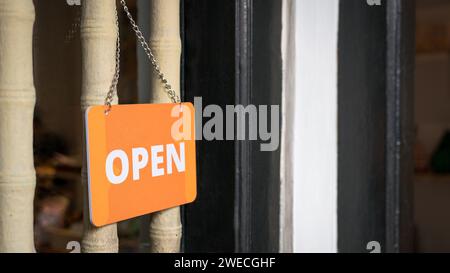 Text, auf einem orangefarbenen Schild außerhalb eines Geschäfts öffnen. Offen für Geschäftskonzept. Stockfoto
