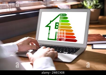 Energieeffizienz. Mann mit Laptop mit bunten Bewertungen am Tisch, Nahaufnahme Stockfoto