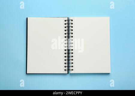 Öffnen Sie das Notizbuch auf hellblauem Hintergrund, Ansicht von oben Stockfoto