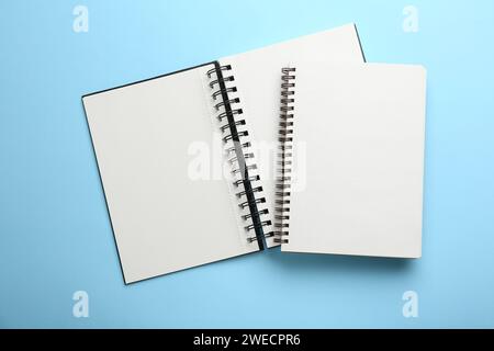 Zwei Notizbücher auf hellblauem Hintergrund, Draufsicht Stockfoto