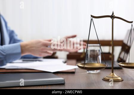 Der Anwalt arbeitet am Holztisch, konzentriert sich auf die Waage der Gerechtigkeit Stockfoto