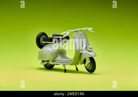 Foto einer alten Miniatur-Vespa, die auch Roller genannt wird. Mit grünem Hintergrund fotografiert, um das graue Vespa-Objekt zu isolieren Stockfoto