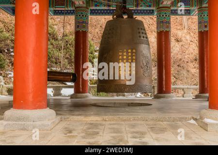 Riesige Messingglocke im farbenfrohen Pavillon am Guinsa-Tempel in Südkorea Stockfoto