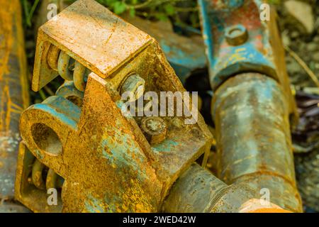 Großaufnahme von verrosteten Metallmaschinenteilen, die entsorgt und auf dem Boden liegen Stockfoto