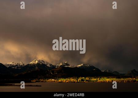 Hopfensee mit stürmischem Himmel im sanften Morgenlicht und Allgäu-Bergen im Hintergrund, Hopfen am See, Ostallgäu, Schwaben, Bayern, Deutschland Stockfoto