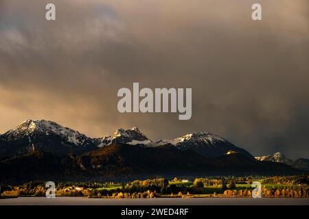 Hopfensee mit stürmischem Himmel im sanften Morgenlicht und Allgäu-Bergen im Hintergrund, Hopfen am See, Ostallgäu, Schwaben, Bayern, Deutschland Stockfoto