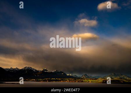 Hopfensee mit stürmischem Himmel im sanften Morgenlicht und Allgäu-Bergen im Hintergrund, Hopfen am See, Ostallgäu, Schwaben, Bayern, Deutschland Stockfoto