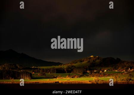 Hopfensee mit stürmischem Himmel im sanften Morgenlicht und Allgäu-Bergen im Hintergrund, Hopfen am See, Ostallgäu, Schwaben, Bayern, Deutschland Stockfoto