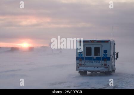 Der Krankenwagen fährt durch das Dorf Inupiaq Kaktovik während eines Schneesturms bei Sonnenuntergang, Barter Island, 1002 Gebiet des Arctic National Wildlife Refuge, Stockfoto