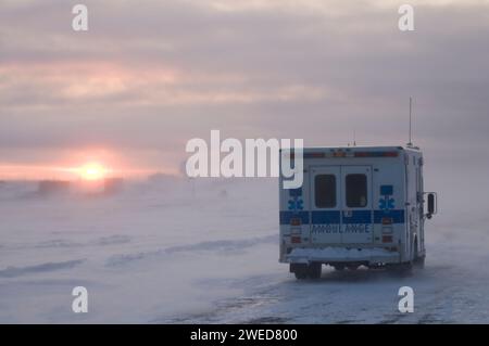 Der Krankenwagen fährt durch das Dorf Inupiaq Kaktovik während eines Schneesturms bei Sonnenuntergang, Barter Island, 1002 Gebiet des Arctic National Wildlife Refuge, Stockfoto