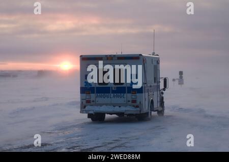 Der Krankenwagen fährt durch das Dorf Inupiaq Kaktovik während eines Schneesturms bei Sonnenuntergang, Barter Island, 1002 Gebiet des Arctic National Wildlife Refuge, Stockfoto