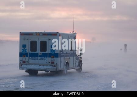 Der Krankenwagen fährt durch das Dorf Inupiaq Kaktovik während eines Schneesturms bei Sonnenuntergang, Barter Island, 1002 Gebiet des Arctic National Wildlife Refuge, Stockfoto