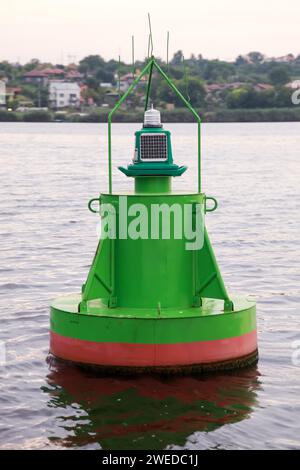 Grüne Navigations-Boje, die auf dem Seewasser schwimmt. Vertikales Foto. Varna, Bulgarien Stockfoto