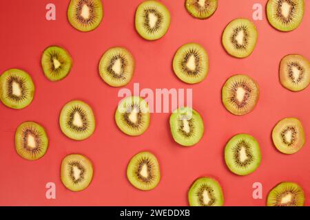 Scheiben frischer saftiger Kiwi auf rotem Tisch, Draufsicht Stockfoto