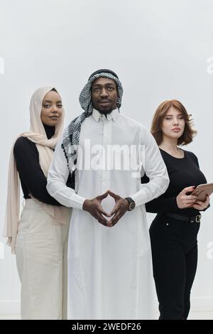 Der arabische Geschäftsmann steht selbstbewusst neben zwei Geschäftsfrauen und stellt ein kompetentes und vielfältiges Team dar, das Ambitionen, Innovation und verkörpert Stockfoto