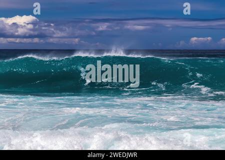 Große Wellen, die vor der Küste brechen, Kona-Küste, Big Island von Hawaii. Blauer Himmel und Wolken im Hintergrund. Stockfoto