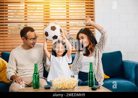 Eine glückliche Familie genießt den Nervenkitzel eines Fußballspiels zu Hause Stockfoto