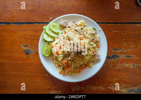 Hausgemachter gebratener Reis mit gemischter GemüseKarotte, grünen Bohnenerbsen, Mais und Ei mit Schweinefleisch auf weißem Teller. Schweinefleisch gebratener Reis mit Ei und Tomaten. asiatisch für Stockfoto