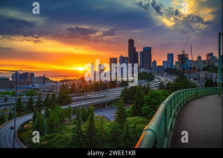 Dramatischer Sonnenuntergang über der Skyline von Seattle mit dem Highway im Vordergrund Stockfoto