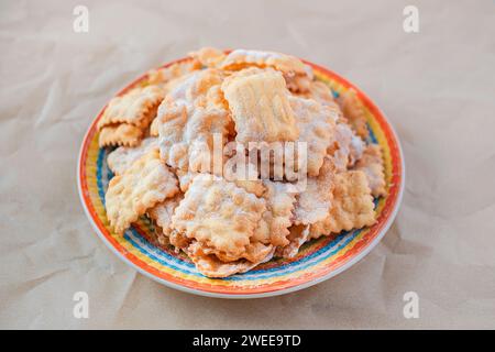 Traditionelles süßes knuspriges Gebäck, frittiert und mit Puderzucker bestreut. Karnevalskosttradition. Stockfoto