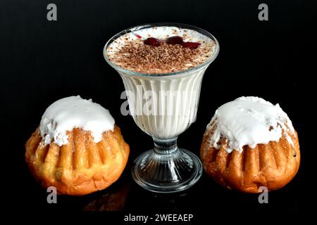 Zwei Butterkuchen mit Vanille, Rosinen, eingeweicht in Rum namens Baba und ein Quark-Dessert mit Beeren. Stockfoto