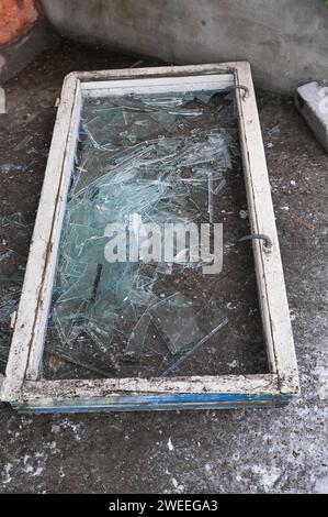 Ein kaputtes altes Fenster. Glassplitter auf dem Boden Stockfoto