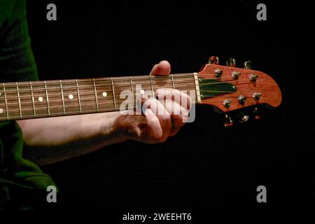 Bild eines Musikers, der einen Akkord am Gitarrenhals spielt Stockfoto