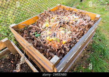 Ein Komposter aus Holzbrettern, gefüllt mit Bioabfall aus der Küche. Stockfoto