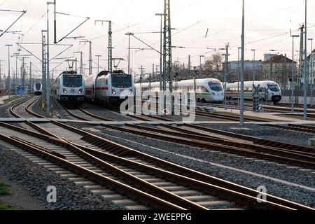 Geparkte Regional- und Intercity-Züge auf Abstellgleisen vor dem Leipziger Hauptbahnhof. Tracks und Schalter im Vordergrund. Bewölkter Himmel Stockfoto