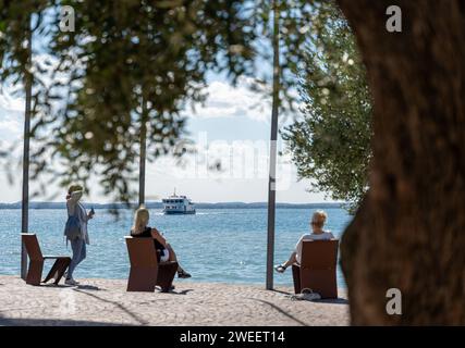 Lazise, Gardasee, Italien - 20. September 2022: Touristen warten am Gardasee in Lazise auf ein Fährboot, das gerade ankommt *** Touristen wartem am Gardasee in Lazise auf ein Fährboot das gerade ankommt Stockfoto