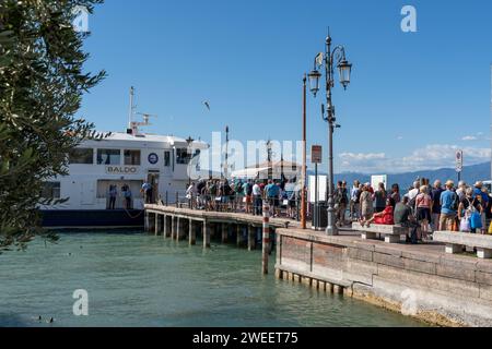 Lazise, Gardasee, Italien - 20. September 2022: Touristen steigen am Fährhafen Lazise am Gardasee in Italien an Bord einer Fähre *** Touristen am Fährhafen von Lazise am Gardasee in Italien steigen in eine Fähre ein Stockfoto