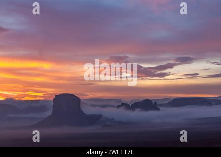 Farbenfrohe Sonnenaufgangswolken über Elephant Butte & Camel Rock im Monument Valley Navajo Tribal Park in Arizona. Stockfoto