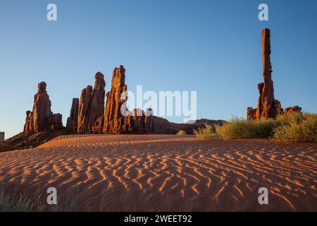 Der Totem Pole & YEI BI Chei mit gewellten Sanddünen im Monument Valley Navajo Tribal Park in Arizona. Stockfoto