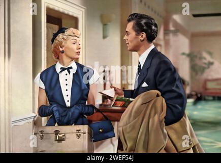 Dirk Bogarde und Yolande Donlan spielen die Hauptrollen in „Penny Princess“ (1952), einer leichtsinnigen britischen Komödie. In diesem Film spielt Bogarde Tony Craig, einen unternehmungslustigen jungen Geschäftsmann, während Donlan Lindy Smith darstellt, einen skurrilen Amerikaner, der ein kleines europäisches Königreich erbt. Die Geschichte dreht sich um ihre humorvollen Bemühungen, die kämpfende Nation durch einzigartige und skurrile Strategien zu retten. Stockfoto