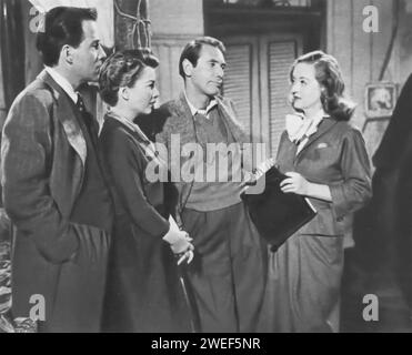 Bette Davis, Anne Baxter, Gary Merrill und Hugh Marlowe sind die Hauptrollen in „All About Eve“ (1950), einem Film, der für seine scharfen Dialoge und die Erforschung der Ambitionen in der Theaterwelt bekannt ist. Davis spielt Margo Channing, einen etablierten Broadway-Star, Baxter ist Eve Harrington, eine aufstrebende Schauspielerin, Merrill stellt Bill Sampson, einen Theaterregisseur und Margos Freund dar, und Marlowe spielt den Dramatiker Lloyd Richards. Der Film befasst sich mit Eves manipulativem Aufstieg im Theaterkreis und beeinflusst das Leben und die Beziehungen der anderen Charaktere. Stockfoto