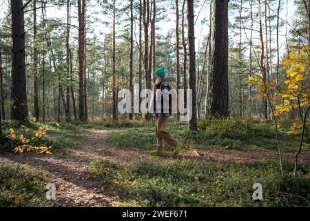Touristenfrau, die Zeit zur freien Verfügung im Kiefernwald beim Wandern, Entspannen und Einatmen der frischen Luft verbringt Stockfoto