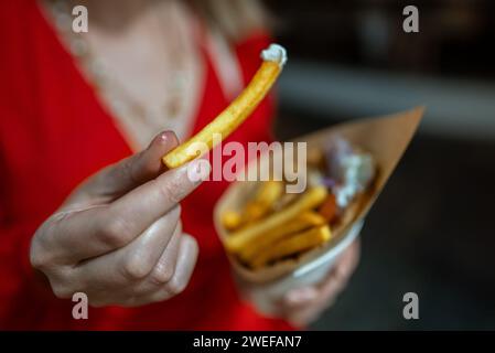 Frau isst Pita mit pommes frites. Stockfoto