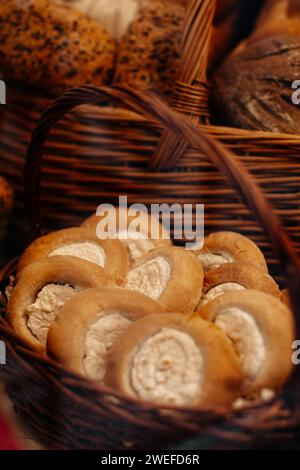 Frisch gebackene Brotbrötchen mit Hüttenkäse in einem Korb. Bäckerei, Theke Stockfoto