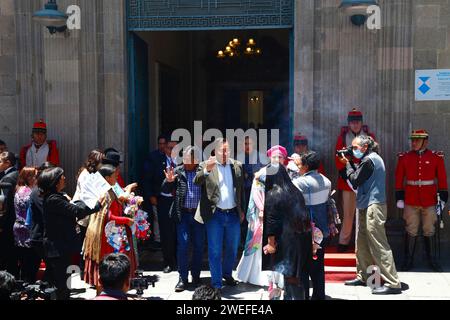 La Paz, BOLIVIEN; 24. Januar 2024: Ein Mitglied des Pressebüros des Präsidenten macht Fotos von dem bolivianischen Präsidenten Luis Arce Catacora (Zentrum) und der Ministerin der Präsidentschaft María Nela Prada Tejada (mit rosa Kopfschmuck), als sie den ehemaligen Präsidentenpalast verlassen, um das heute begonnene Alasitas-Festival zu besuchen. Alasitas ist ein populäres fest, das vor allem in La Paz gefeiert wird. Es ist üblich, dass Präsidenten und andere Minister kurz vor Mittag, dem Zeitpunkt, an dem die wichtigsten Segenszeremonien stattfinden, besuchen. Stockfoto