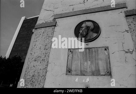 DDR, Berlin, 08.08.1990, in diesem Haus Friedrichstraße / Ecke Clara-Zetkin-Straße heute Dorotheenstraße wurde eine Gedenktafel für Friedrich Engels abmontiert, der Kopf hängt noch. Taltext: Friedrich Engels, 28. Nov. 1820 Bis 5. August 1895. Dem Mitbegründer des wissenschaftlichen Sozialismus und Kampfgefährte von Karl Marx wohnte 1841/42 in diesem Haus., im Hintergrund das Internationale Handelszentrum, Rolf Zoellner Gedenktafel Friedrich Engels *** DDR, Berlin, 08 08 08 1990, in diesem Haus Friedrichstraße Ecke Clara Zetkin Straße heute war die Dorotheenstraße eine Gedenktafel für Friedrich Engels Stockfoto