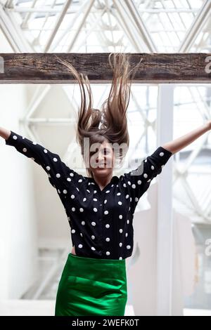 Eine junge Frau, die ihr Haar hochwirft Stockfoto