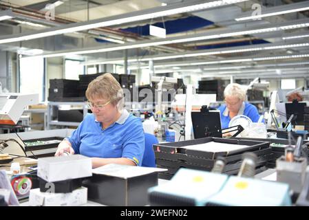 Freundliche Frau in einem mikroelektronikfertigung Factory-Komponenten Montage und Löten arbeiten Stockfoto