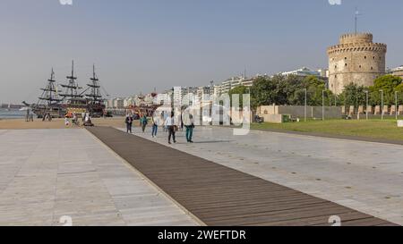 Thessaloniki, Griechenland - 22. Oktober 2023: Menschen gehen am Weißen Turm der Thessaloniki Square Promenade Historisches Wahrzeichen am sonnigen Herbsttag. Stockfoto