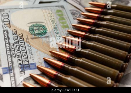 Kampfarmee-Kugeln, Patronen liegen auf US-Dollar-Banknoten, das Konzept des Waffenhandels, die Finanzierung militärischer Operationen, militärische Hilfe. Stockfoto