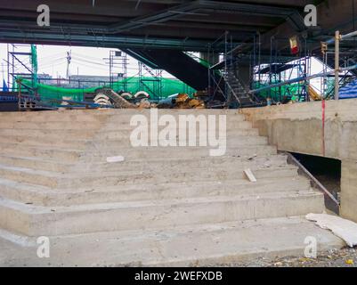 Die unvollendete Betontreppe des Eingangs zum Monorail-Bahnhof im Vorort nahe der Kreuzung, Vorderansicht mit dem Kopierraum. Stockfoto