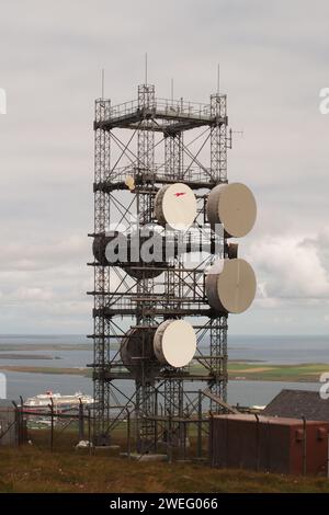 Übertragungsmast in Wideford Hill, Kirkwall, Orkney, Schottland, Großbritannien, mit der Fähre von Aberdeen, die am Pier unten liegt Stockfoto